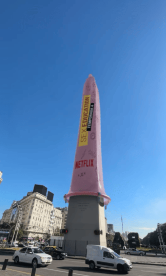 Foto do Obelisco de Buenos Aires com uma camisinha cor-de-rosa gigante, escrita Sesx Education, Temporada 4, Netflix.